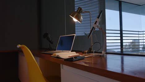 laptop and smartphone on desk with notebook and lamp in home office setup, copy space