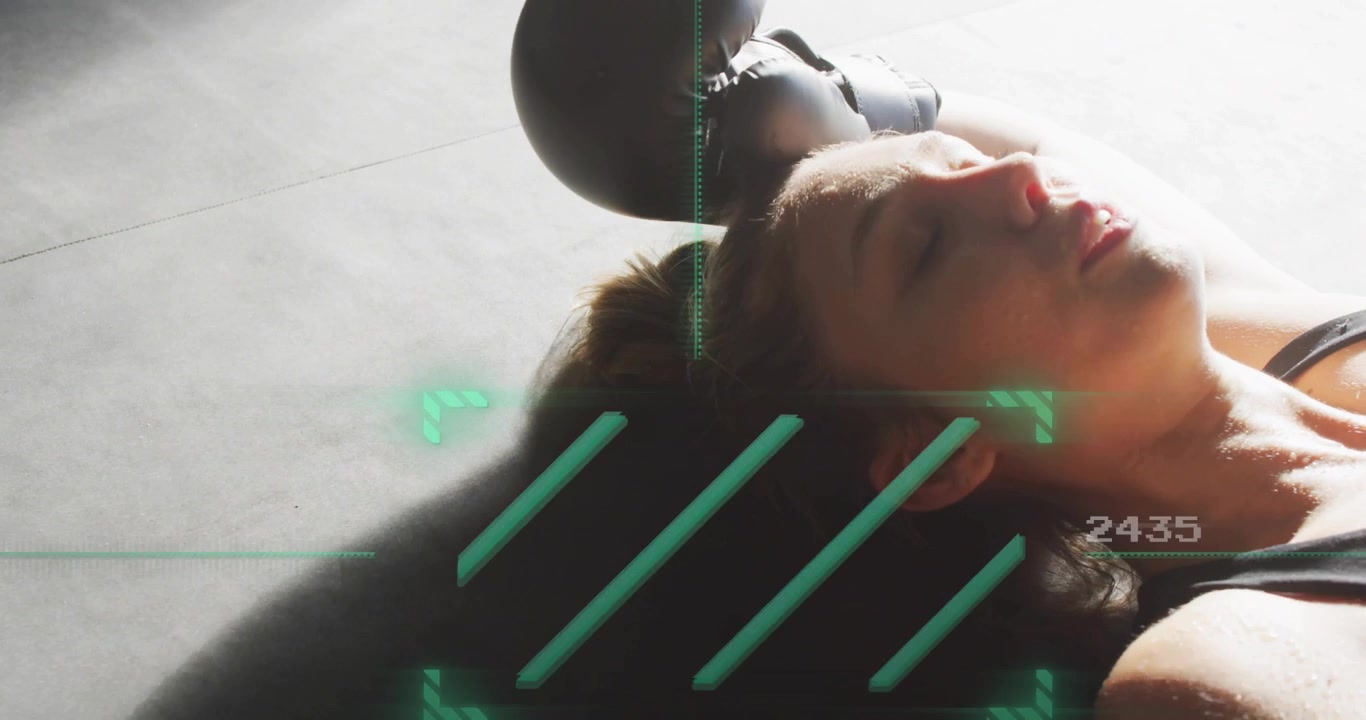 Gloved female athlete lying on mat receiving green overlay and extending arms overhead for fitness