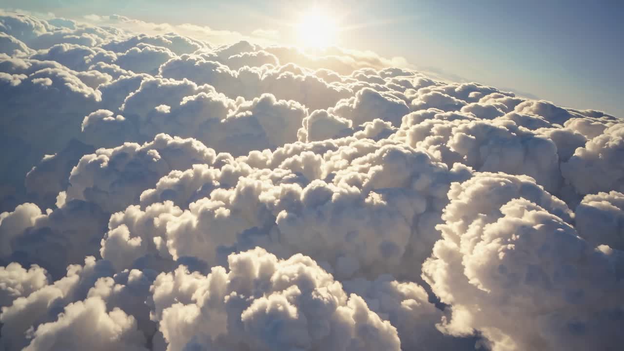 Aerial video view of fluffy clouds with sunlight streaming through, creating a serene and dreamy