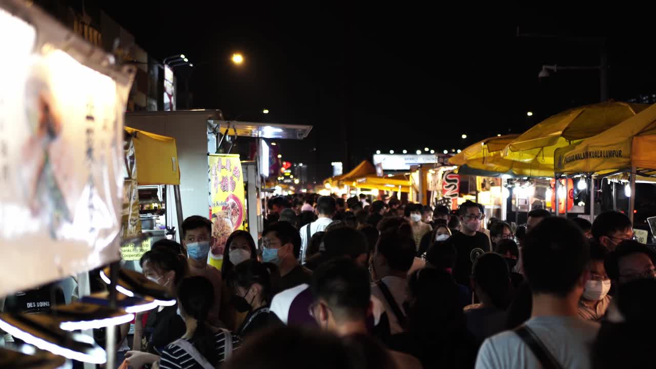 Busy Night Market with Crowds of People Eating Street Food