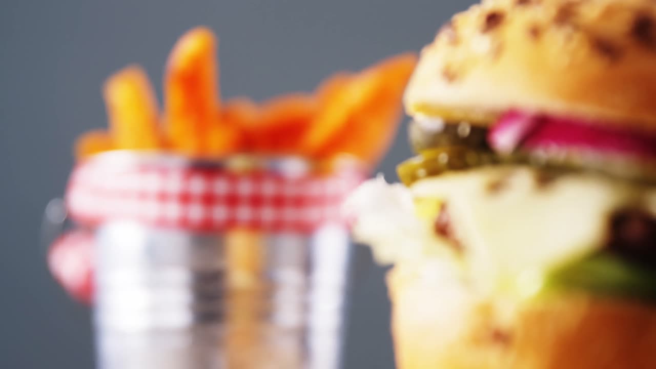 hamburguesa y papas fritas contra un fondo gris