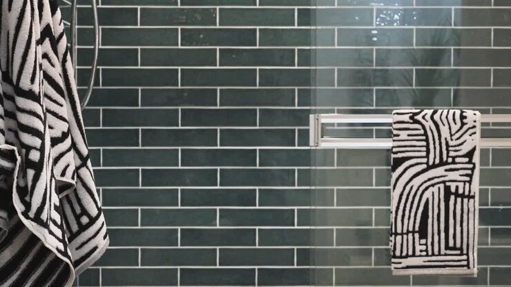 A modern luxury shower with cool green reflective tile