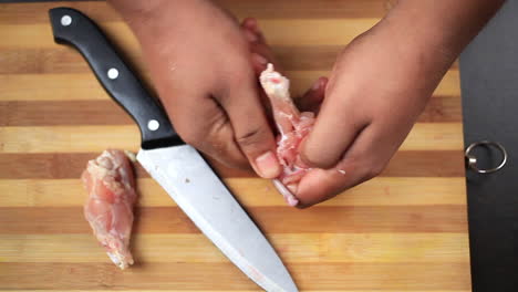 alitas de pollo frescas cortadas por el chef con un cuchillo para darle forma de piruleta para preparar comida china