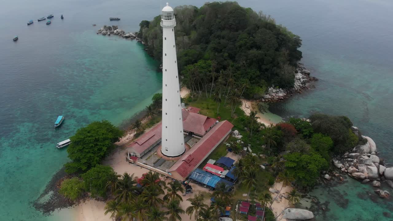 Belitung Endonezya'da deniz ve plajla çevrili Pulau Langkuas adasındaki manzaralı deniz fenerinin hava görüntüsü.