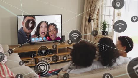 Animation-of-media-icons-over-biracial-family-having-tv-video-call