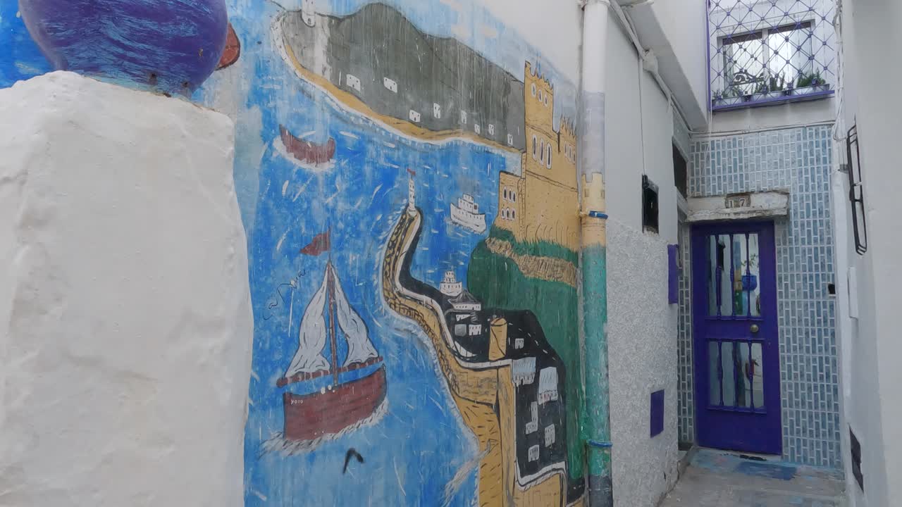 pintura en una pared blanca en un pequeño callejón en la medina de tánger, tiro inclinado hacia abajo