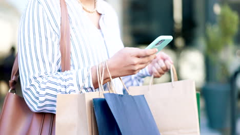 Mujer,-Teléfono-Y-Manos-Con-Bolsa-De-Compras-En-La-Ciudad.