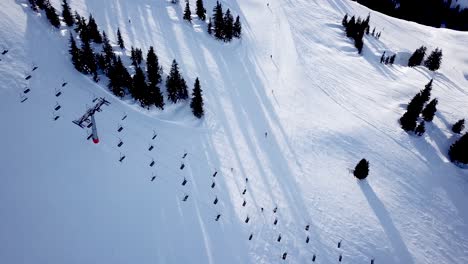 aerial view of people skiing and snowboarding on hill, ski resort