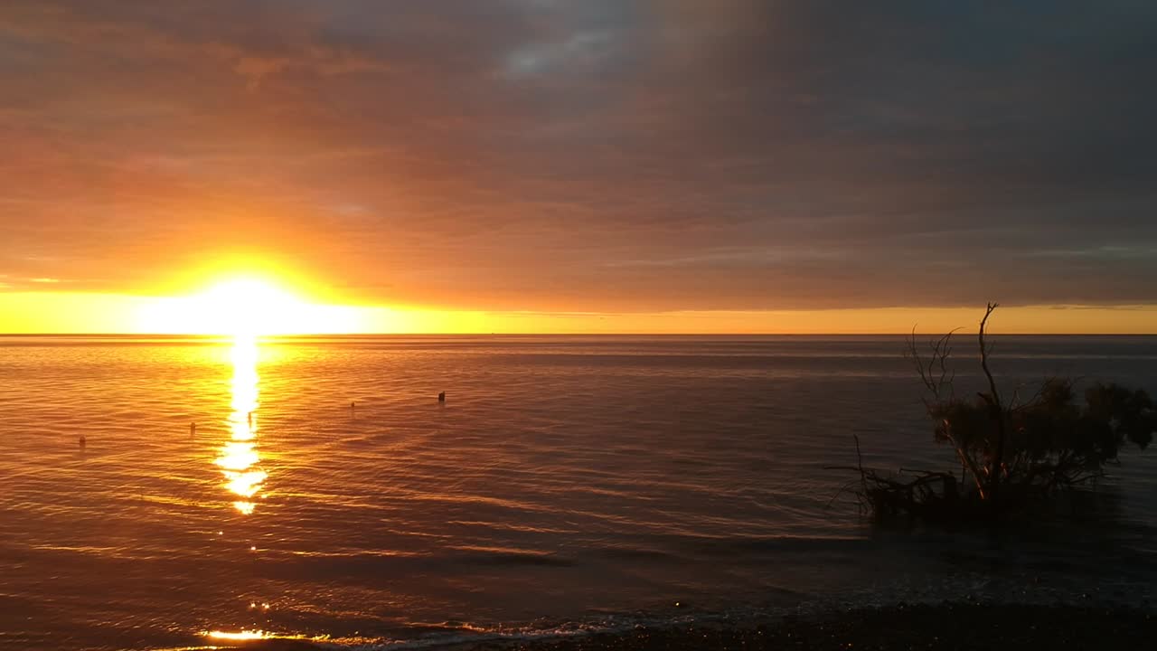 The sun breaks on a new day over the ocean, low cloud provides a dramatic effect at sunrise