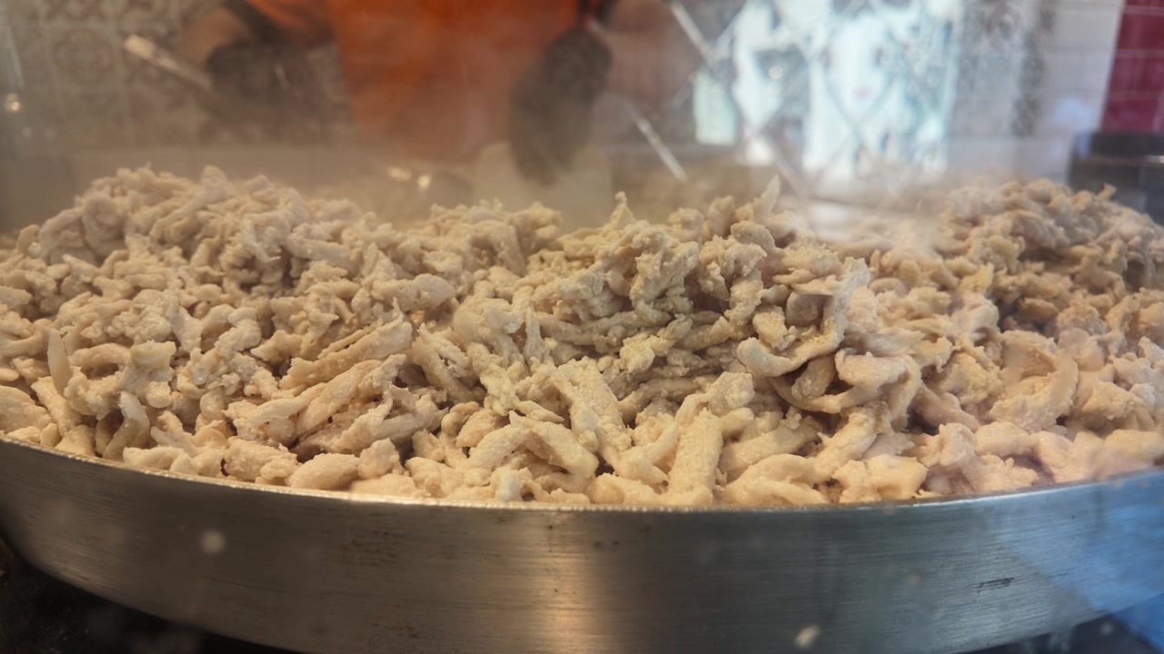 Chef Cooking Shredded Chicken in Large Pan