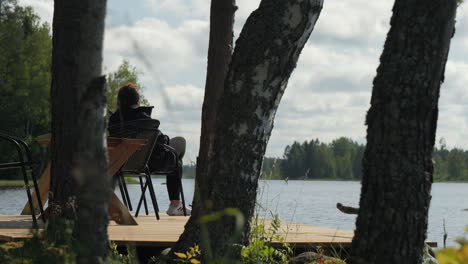 Wooden-pier,-birch-forest-and-calm-lake-water---perfect-spot-for-relaxing