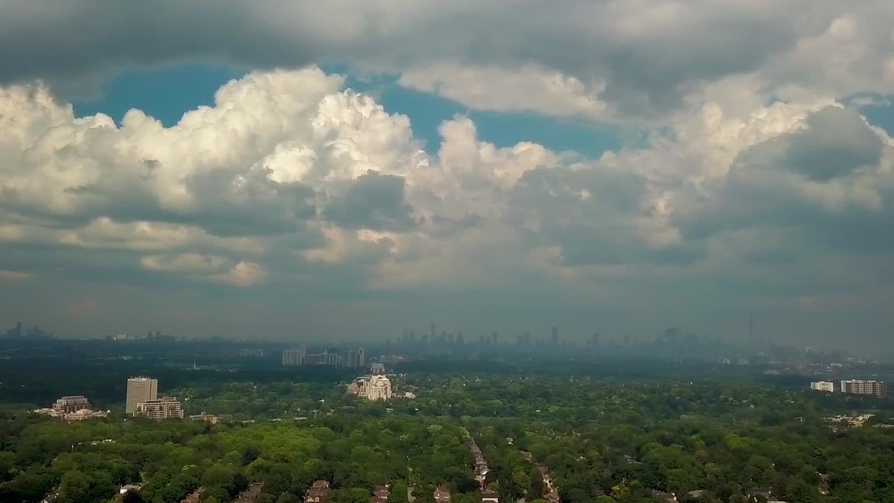 Aerial Drone Pan, Summer Thunder Storm Clouds and Sunlight over Big City. Epic Rainy Sky casts Shadows on Urban Downtown Houses and Office Skyscraper Towers in Toronto Ontario Canada