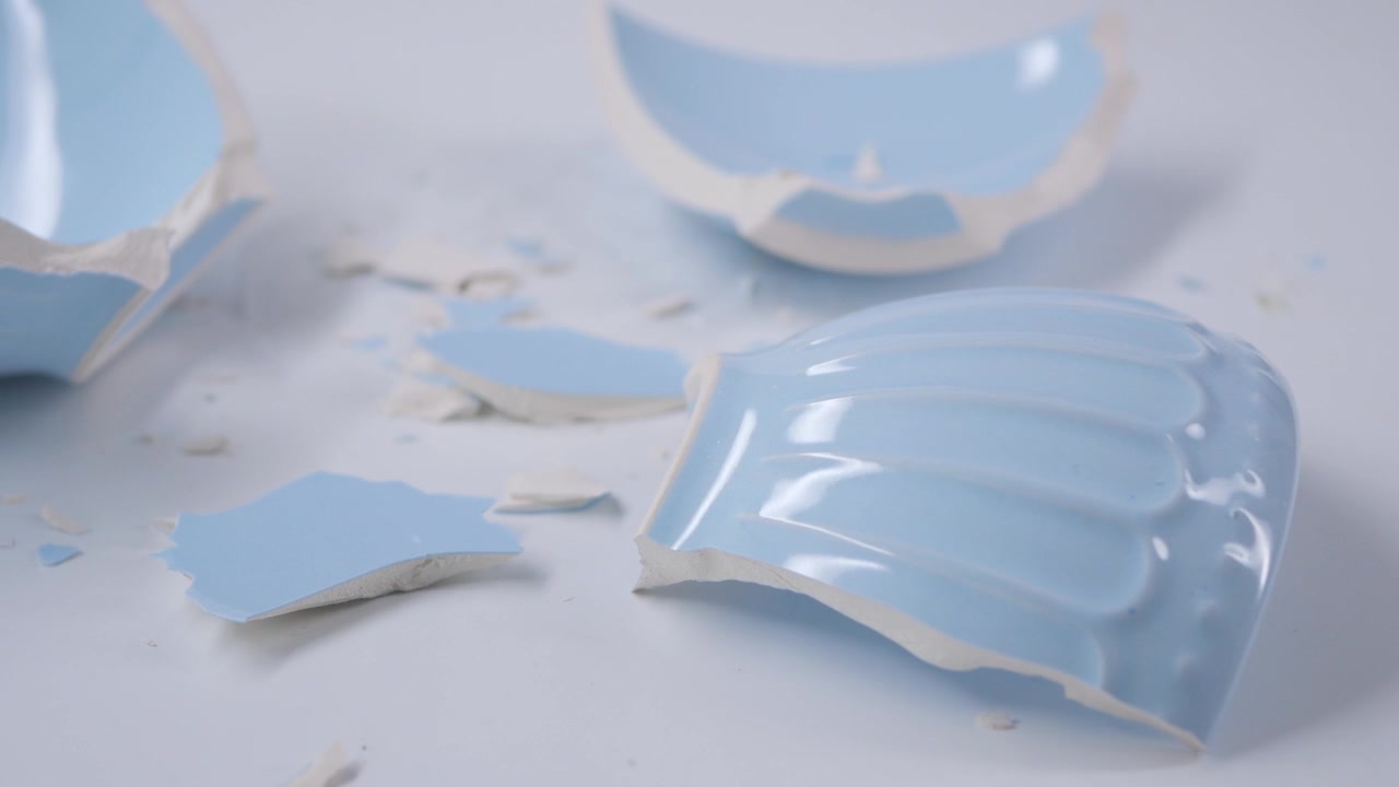 Broken Light Blue Ceramic Bowl Pieces on White Background