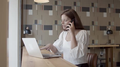 serious female entrepreneur talking on mobile phone