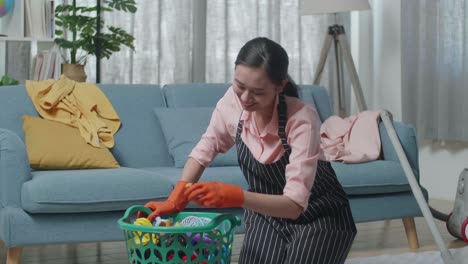woman cleaning up toys in living room