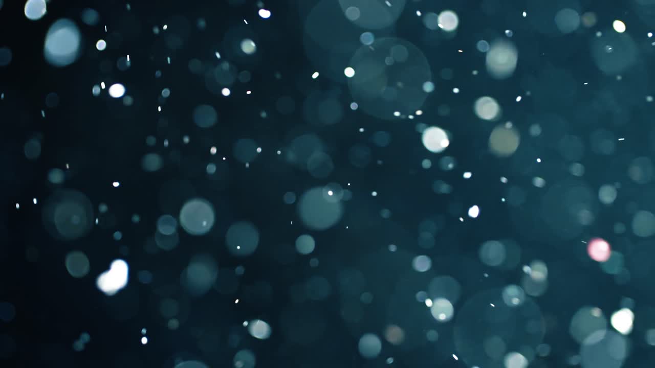 Floating abstract particle bokeh on dark background