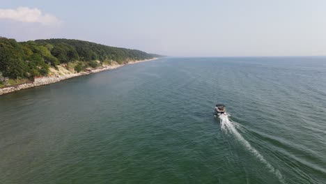 Gorgeous-tracking-shot-of-a-boat-cruising-along-the-Lake-Michigan-Coast-near-Muskegon,-MI