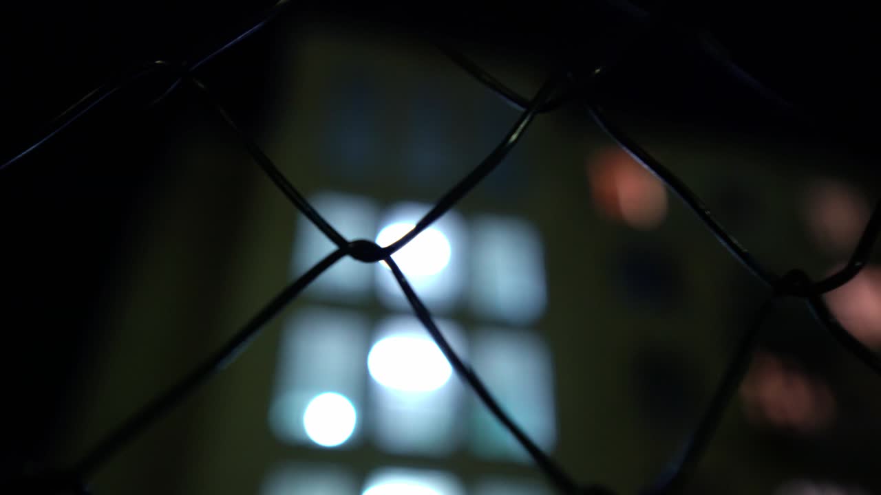 금속망: 밤에 랜턴의 빛에 비어있는 공허한 농구장, 감옥 울타리.