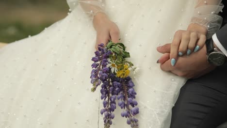 bride and groom holding hands with flowers