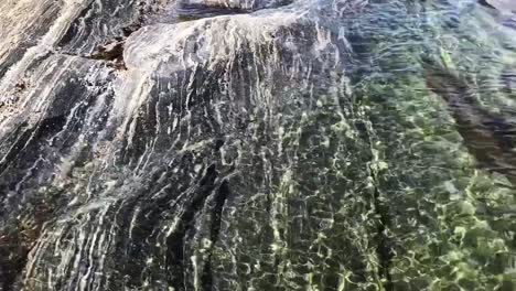 Rocky-shores-in-Karelia,-Russia-with-crystal-clear-blue-water-and-green-surroundings