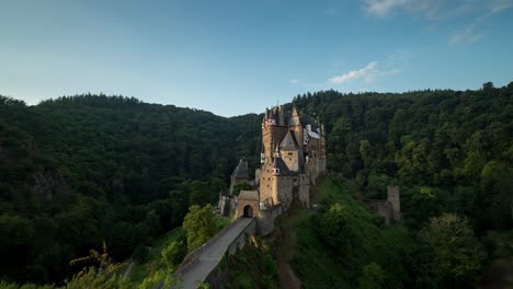 Sunrise-over-the-beautiful-Castle-Eltz,-Germany-by-green-mountains--time-lapse