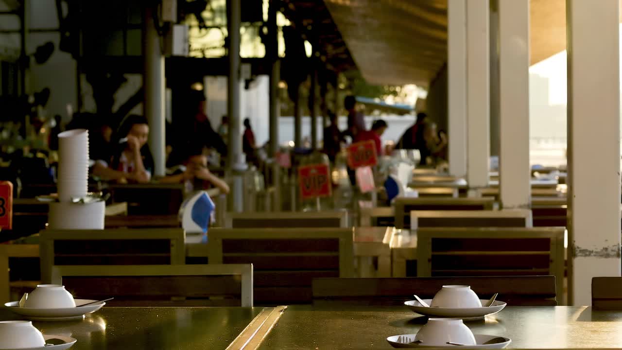 A view of a restaurant interior featuring wooden tables, chairs, and a warm ambiance.