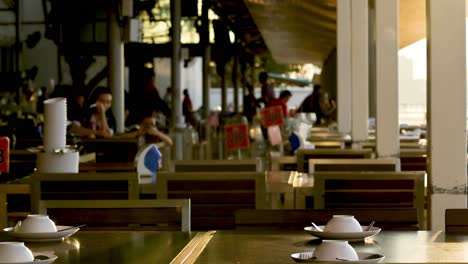 a view of a restaurant interior featuring wooden tables, chairs, and a warm ambiance.