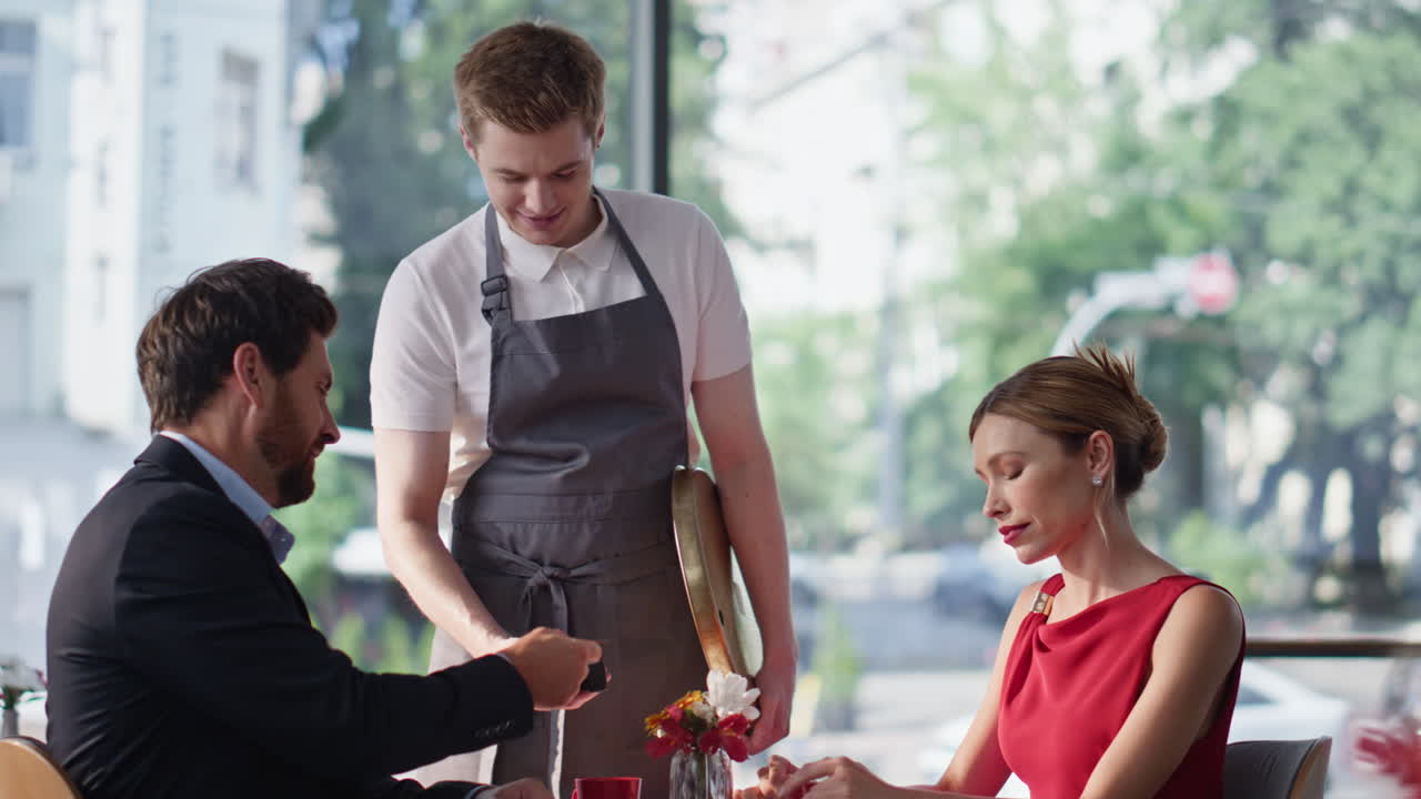 Romantic pair sitting restaurant enjoying time together. Couple paying cafe bill