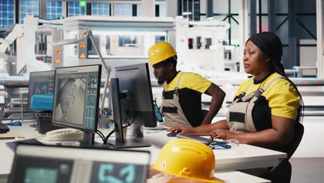 vertical video black factory employee oversees solar system performance at desk