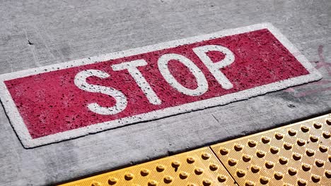 Handheld-shot-of-STOP-written-on-the-ground-from-two-different-angles