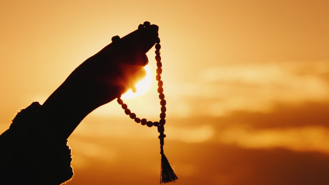 손은 하늘과 석양을 향해 묵주를 들고 진지한 기도와 명상을 한다