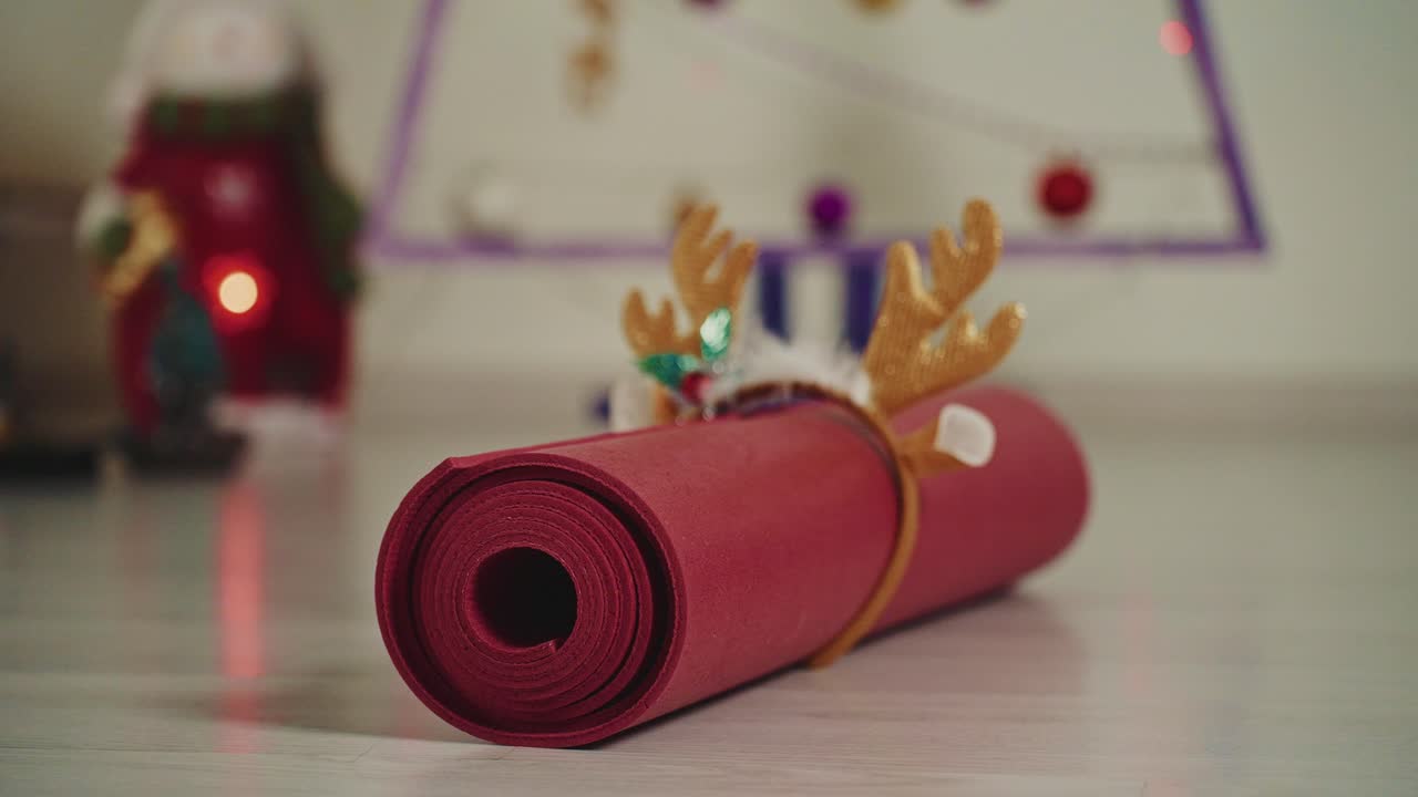 Tapete de yoga com chifres de rena perto de uma árvore de Natal