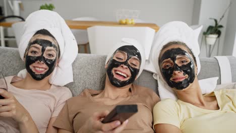 video de tres amigos con máscara facial de carbono viendo televisión