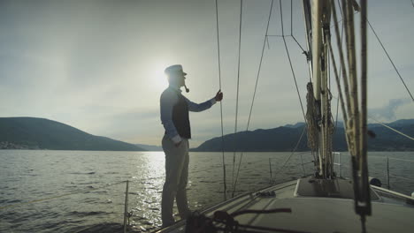 man on yacht deck at sunset