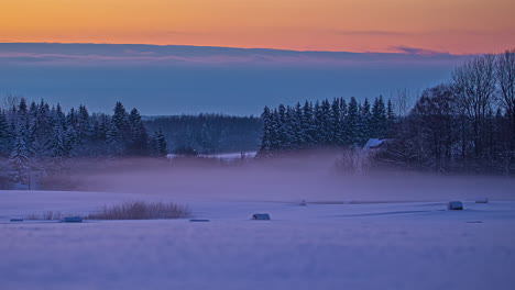 Tiro-De-Campos-Nevados-Con-Fardos-De-Heno-Redondos-En-Una-Fría-Noche-De-Invierno-Con-Niebla-Pasando-En-Timelapse