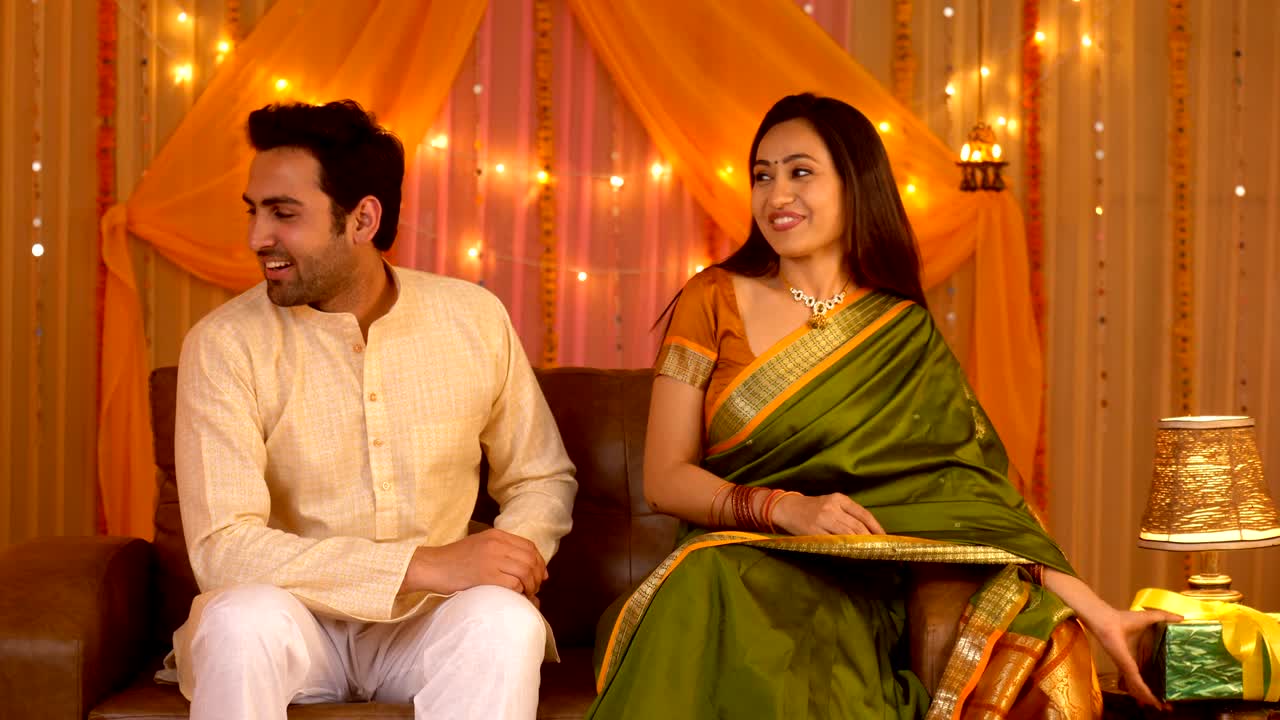 Indian wife surprising her husband with Diwali gift - Festival excitement, happy couple