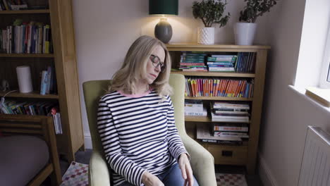 images of a woman sitting in a chair in a living room