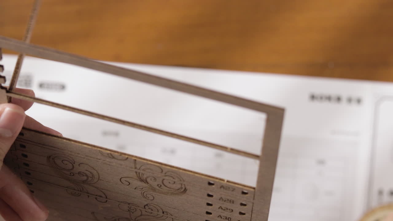 여성의 손은 조립을 위해 나무 색상의 퍼즐 조각을 직접 풉니 다