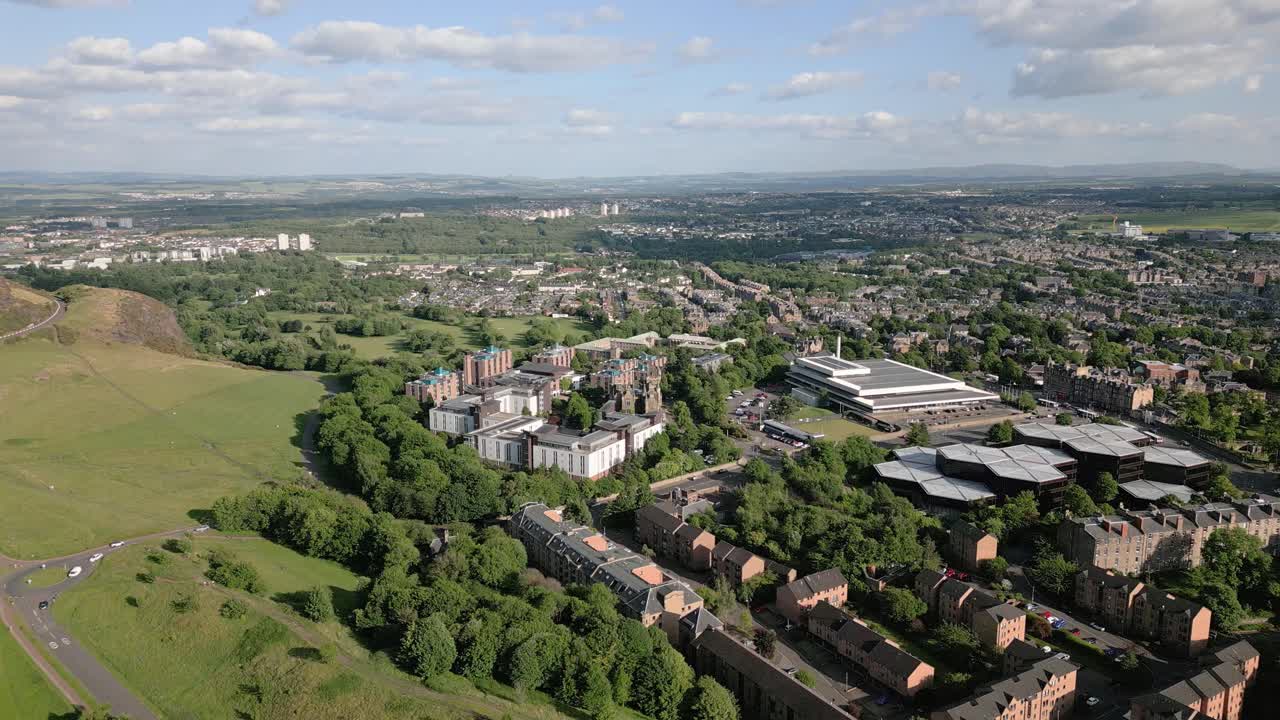 Aerial fly over the Prestonfield suburban area of Edinburgh with grassy hills in sunny day, Scotland, UK