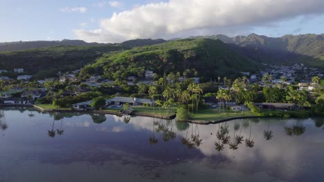 Drohnenaufnahmen-Vom-Stillen-Wasser,-In-Dem-Sich-Die-Palmen-In-Der-Mamala-Bay-In-Honolulu,-Hawaii,-Spiegeln,-über-Die-Viel-Befahrene-Autobahn-Bis-Zu-Den-üppigen-Berggipfeln,-Wo-Die-Ökosysteme-Gemeinsam-Gedeihen