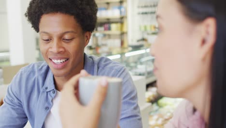 video of happy diverse woman and man talking at coffee shop