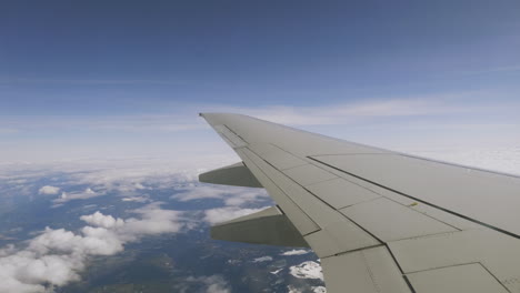Viento-Largo-De-Avión-Volando-A-Través-Del-Cielo-Azul-Brillante-Sobre-Las-Nubes