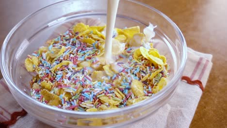 flocos de maíz amarillos crujientes en el cuenco para la mañana un delicioso desayuno con leche. cámara lenta con toma de seguimiento de rotación.