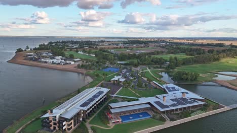 aerial view of the sebel hotel complex with swimming pool tennis courts and golf course beyond