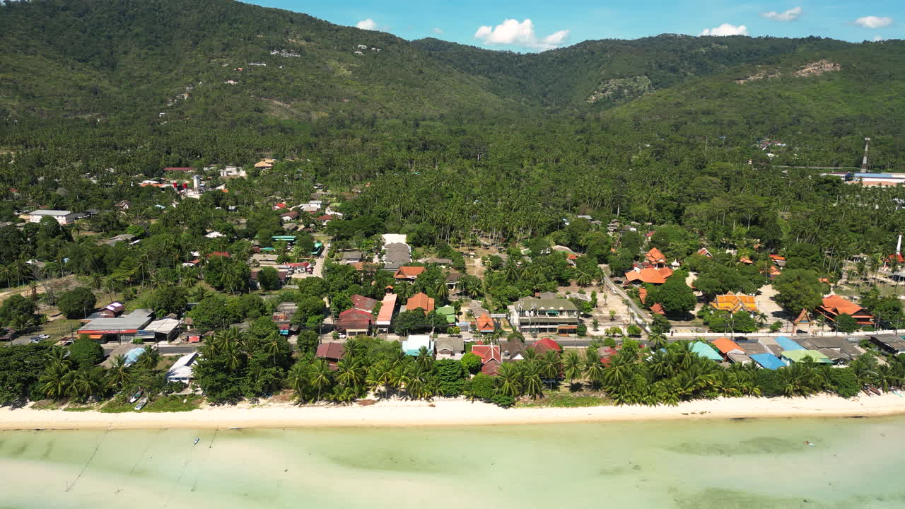 Bang Por Beach and the small town in Koh Samui Thailand with a mountainous background, aerial orbital