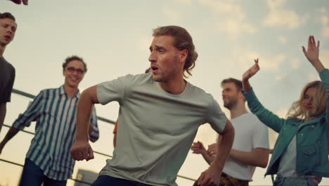 Handsome-guy-having-fun-at-party-in-dusk-time.-Partying-people-dancing.