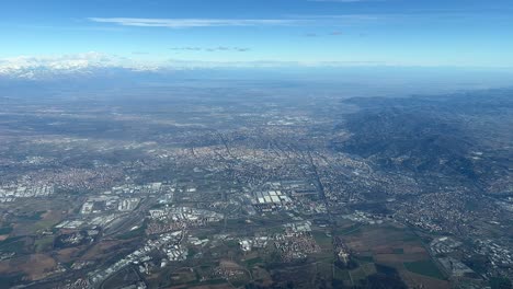 vista aérea de la ciudad de turín en el norte de italia, junto a los alpes italianos nevados en una espléndida y soleada mañana de invierno grabada desde una cabina de jet que sale del aeropuerto