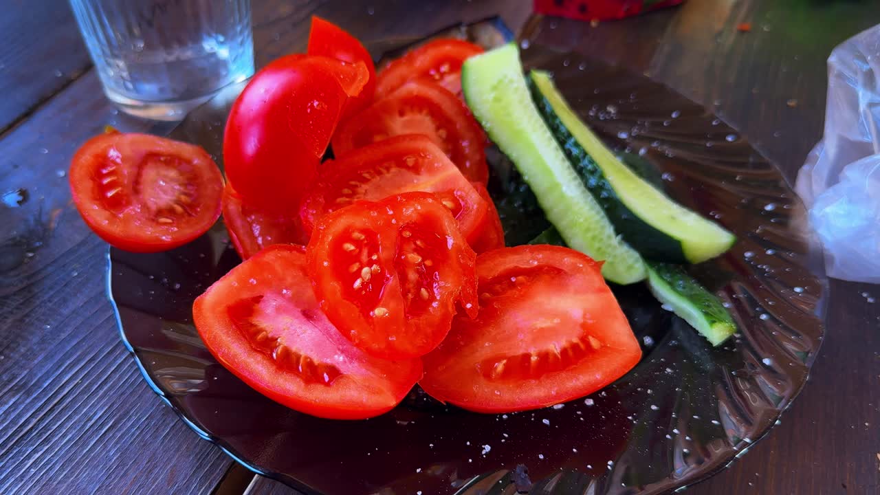 Refreshing Salad Platter with Fresh Tomatoes and Crisp Cucumbers Arranged on a Black Plate, Perfect for Summer Meals and Healthy Snacking