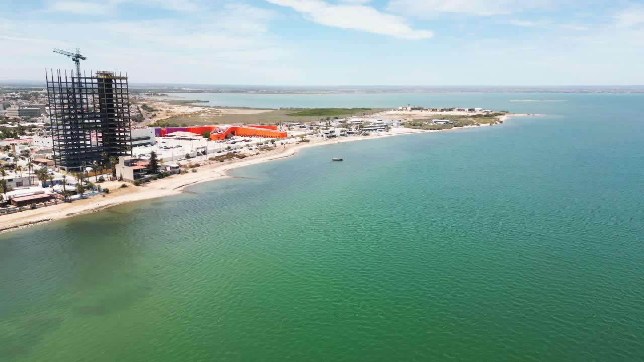 Beachfront view of Playa Posada in La Paz with high-rise construction nearby
