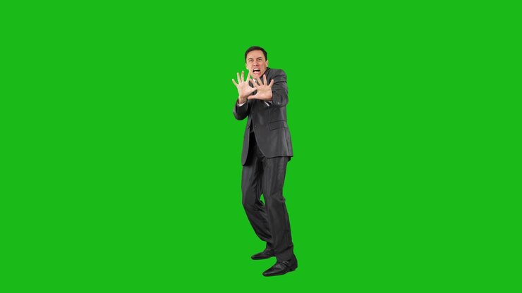 Man in suit expressing fear or repulsion on green screen